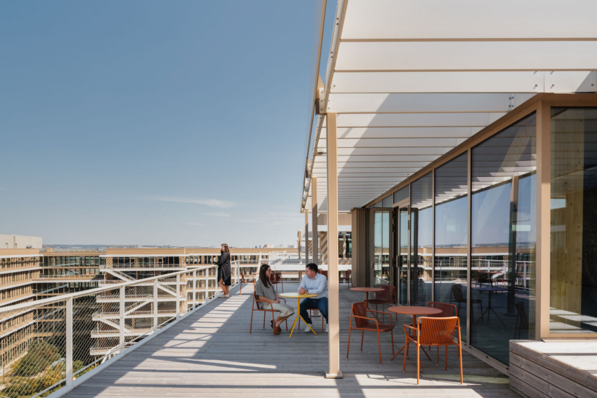 Terrasse du siège DKV conçue par ARCH.DESIGN, espace extérieur lumineux avec mobilier moderne et vue dégagée.