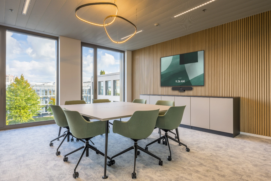 Salle de réunion lumineuse au design épuré et mobilier vert sauge, propice à la collaboration