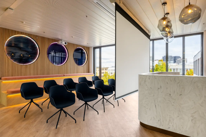 Salle de projection design avec banquette en bois et logo Tristan Capital Partners, pensée pour les moments collectifs