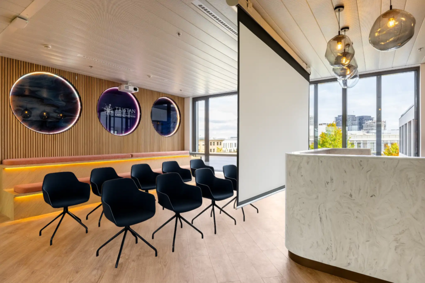 Salle de projection design avec banquette en bois et logo Tristan Capital Partners, pensée pour les moments collectifs