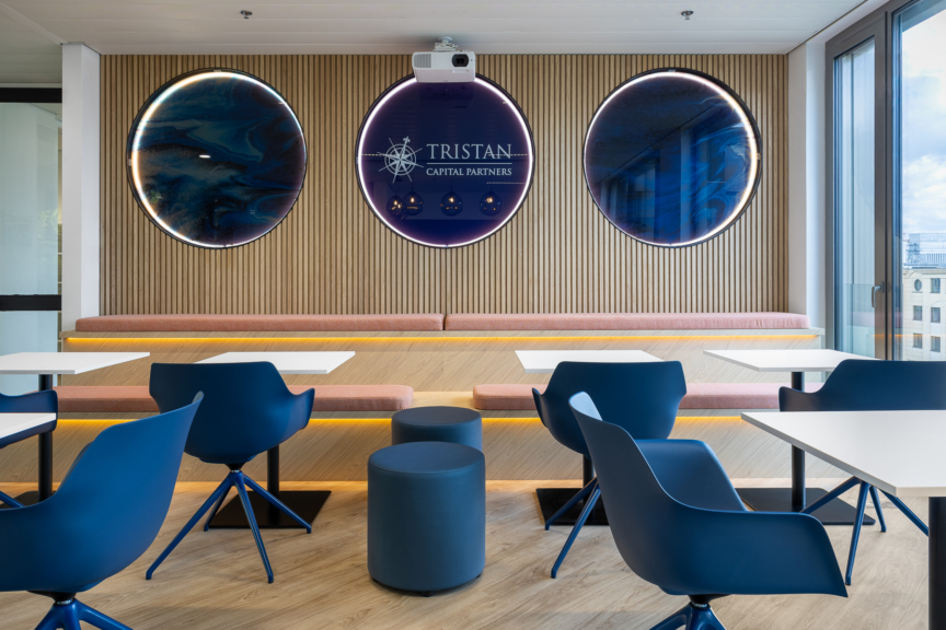 Salle de projection design avec banquette en bois et logo Tristan Capital Partners, pensée pour les moments collectifs