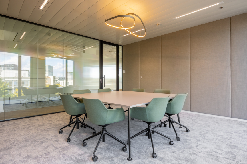 Salle de réunion lumineuse au design épuré et mobilier vert sauge, propice à la collaboration